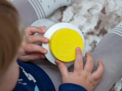 A child playing with a container safely because of child-resistant packaging.